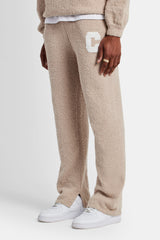 male model wearing the textured spit hem knitted jogger in beige